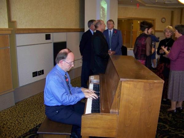Dr Robinson playing ragtime music on the piano in the Michigan Technological University.jpg